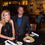 Jewel Davey, property accountant for Mount Pleasant Towne Centre wears a knee length Jessica Howard dress with black sequins and satin ruffle hem while enjoying a calamari appetizer with her co-worker, Andy Lowe, at Carrabba’s in Mount Pleasant. Andy, general manager for Mount Pleasant Towne Centre, wears gray, Calvin Klein suit separates from the Modern Fit Collection. Styling and make-up provided by Belk in Mount Pleasant Towne Centre.