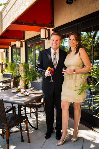 Tom Crawford, wearing a tan dress shirt with Van Heusen black slacks, jacket and patterned tie, is joined by Sissy Baker, sales executive with UNITS Portable Storage. Sissy is wearing a layered gold sheath, knee length Maggie London dress and Nina New York strapped heal shoes. Make-up and styling provided by Belk in Mount Pleasant Towne Centre.