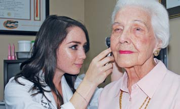 Dr. Casey Adkins runs hearing tests on patient Lib Tiller.
