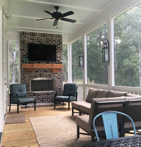 The Caldwell family's screened-in porch functions as an outdoor living room, complete with a television and wood-burning fireplace.