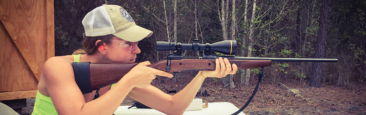 Sarah Carmical aiming a rifle - target practice.