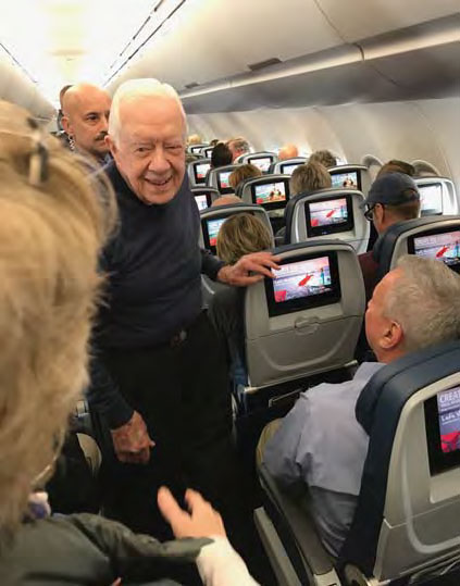 Former President Jimmy Carter walked the length of the plane, greeting Americans of all political beliefs.