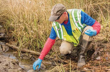 NPDES Inspector Jim Taylor tests the water that empties from a drainage pipe on Rosemead Road.