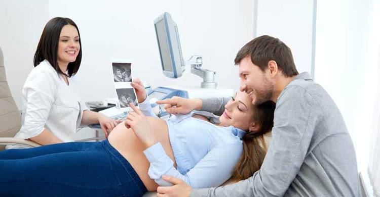 A happy couple looking at a sonogram of their baby