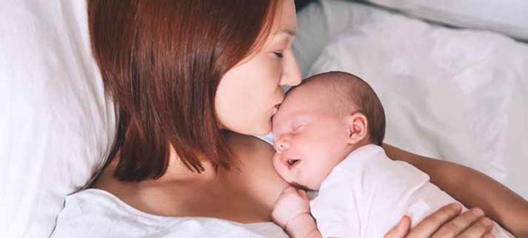 A mother with her infant. Postpartum care article.