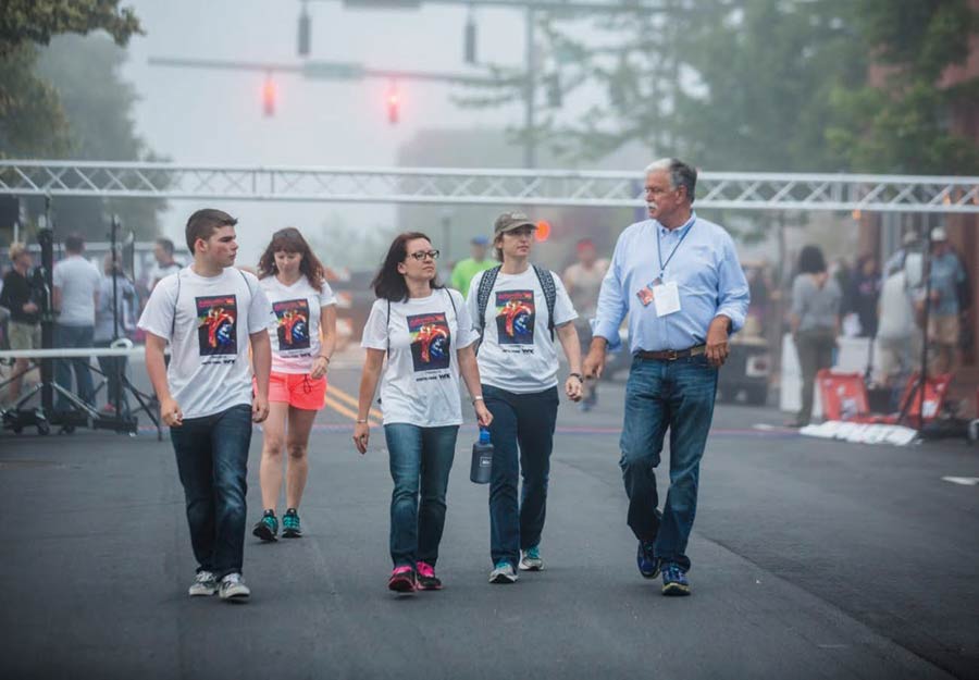 Julian Smith walking with race volunteers at the Asheville Half Marathon.