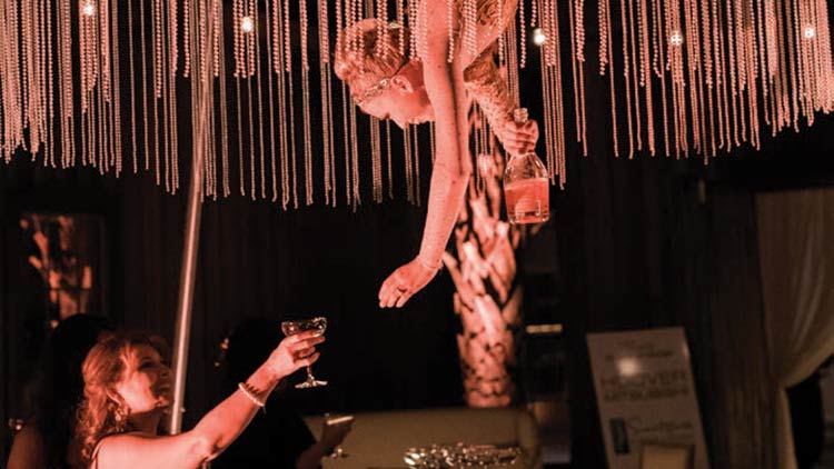 An aerialist pours bubbly at Uncorked.
