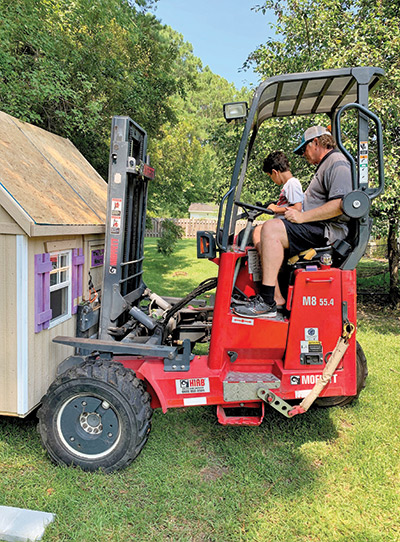 Cayden helps move the clubhouse into his backyard.