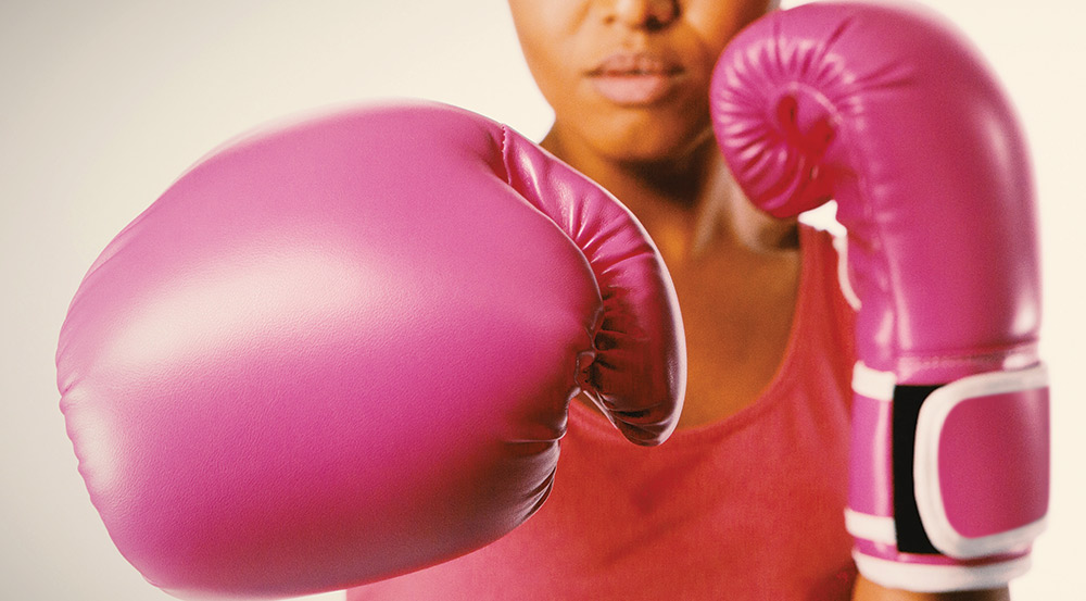 Fighting cancer - Boxer with pink gloves photo