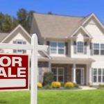 A house with a FOR SALE sign out front.