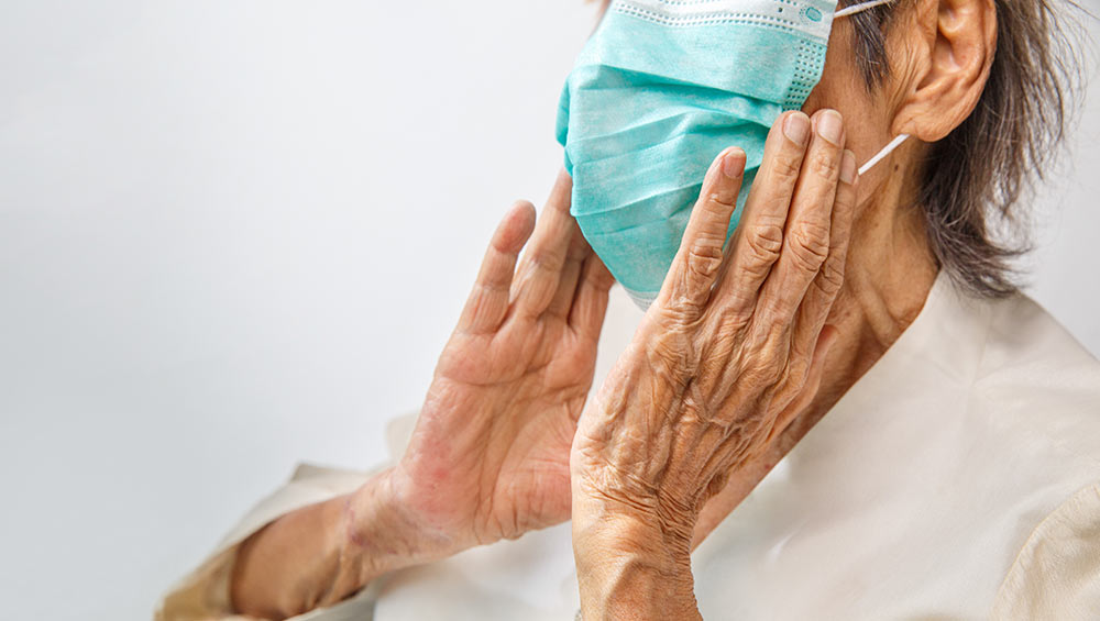 An elderly woman wearing a personal protective mask