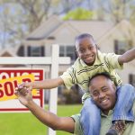 A son and his father smile in celebration after their house has been sold.