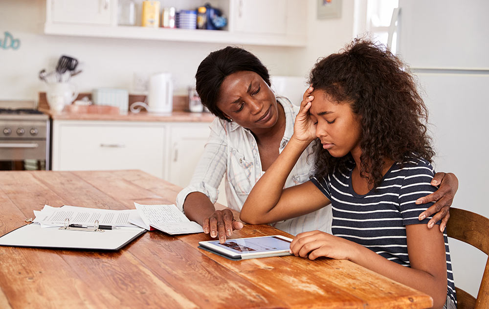 A mother helping her daughter, a stressed teenage student