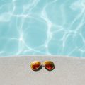 Photo of a swimming pool with sunglasses on the side. (photo by Pexels from Pixabay)