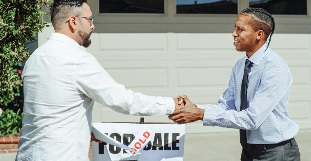 A realtor and home buyer sake hands after the sale of a home. Photo credit Kindel Media on Pexels.