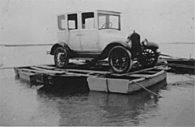 Hecker devised a floating pontoon of three row boats tied together, then balanced his Model T on top and drifted it over to Morris Island. Photo courtesy of Save the Light, Inc.