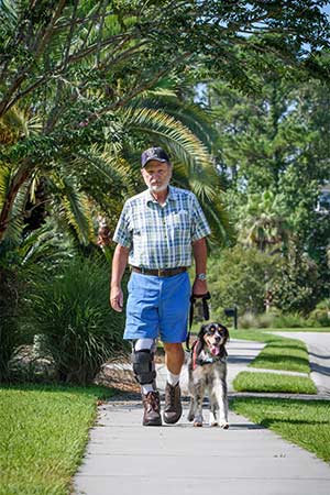 Service dog Sadie walks alongside John Beahm.