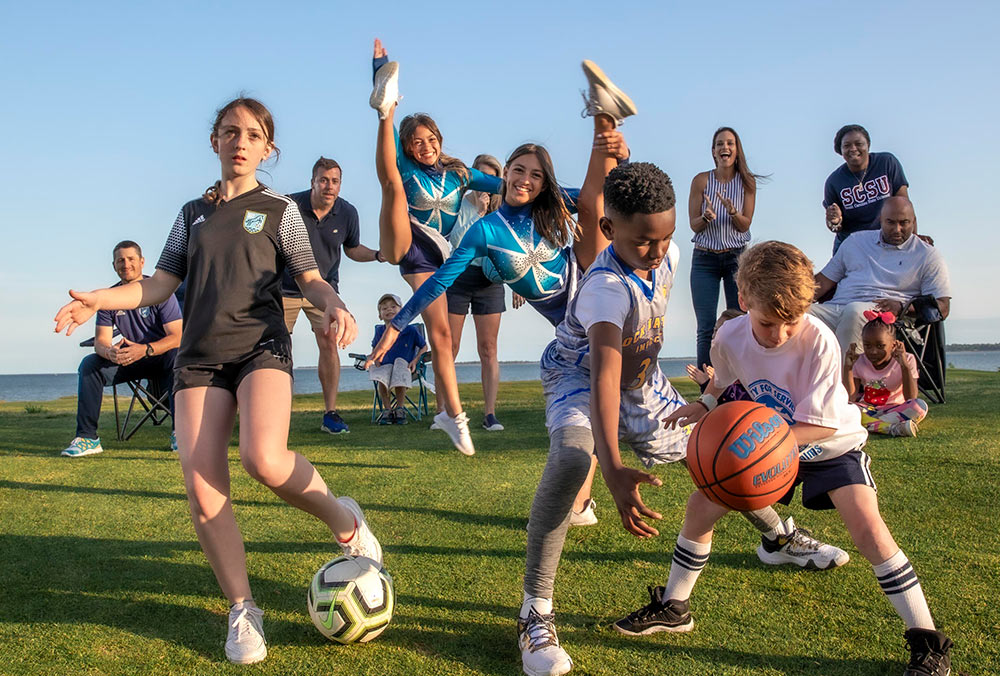 Mount Pleasant parents and their kids in a sports action photo. Photo by MarkStaffPhoto.