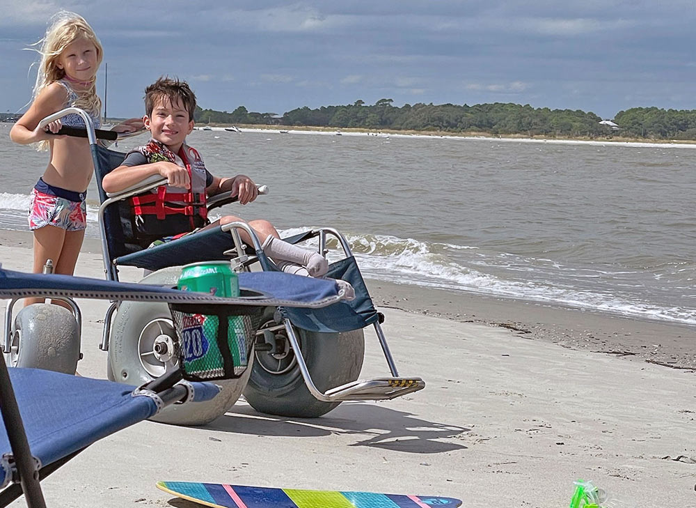Fun in the sun thanks to On Call Mobility. Pictured: 2 kids and a DeBug wheelchair on the beach