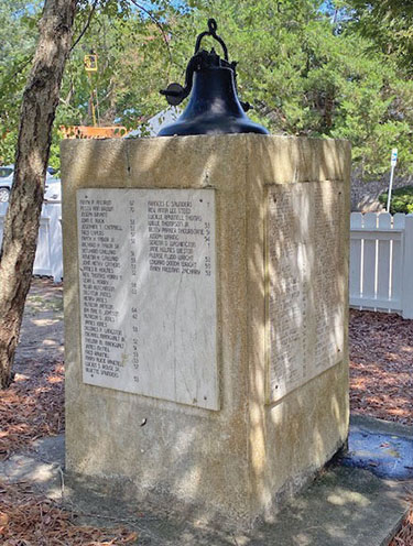 The old school bell stands atop a marker displaying names of former Laing students.