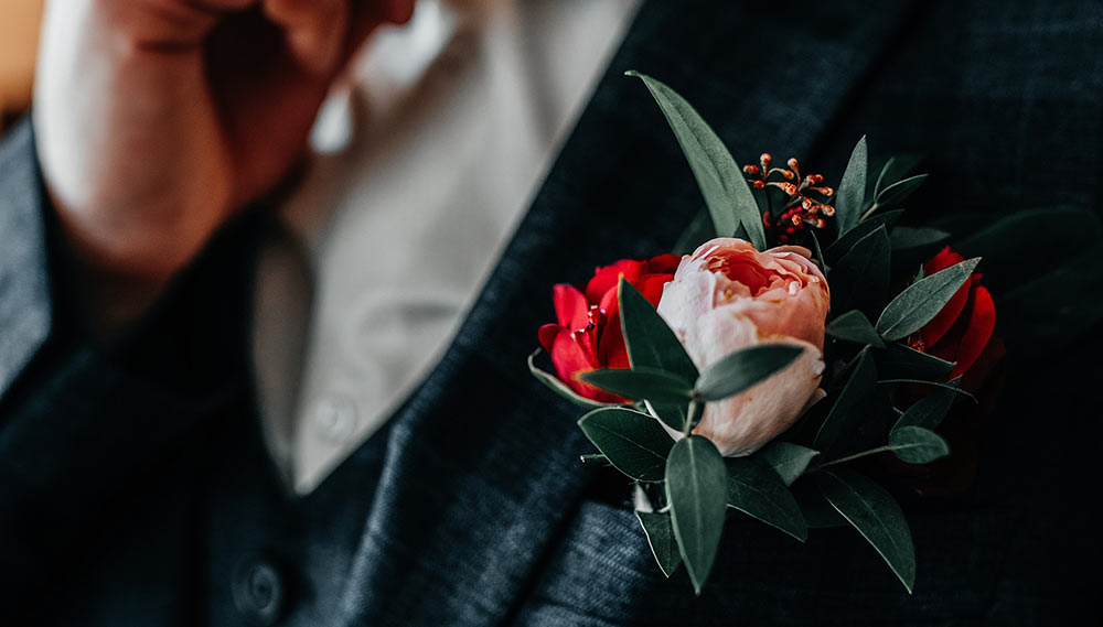 A groom adjusting his bowtie