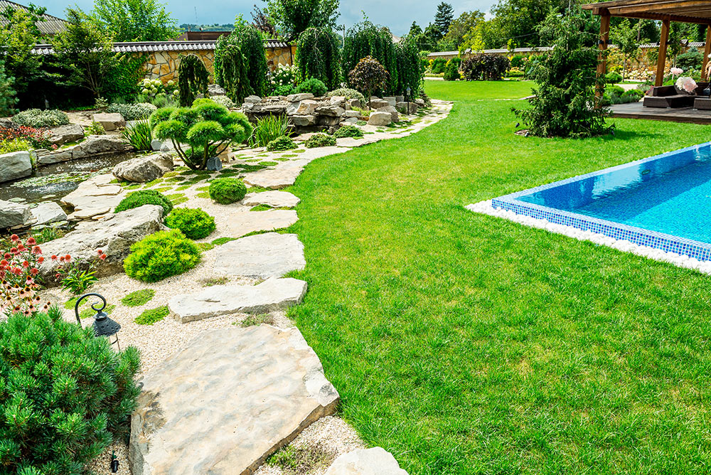 A wonderfully landscaped yard with a pool.