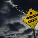"Hurricane Season" road sign with a stormy, dark sky in the background