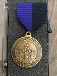 Commemorative 911 medal reads, "Fire Department • City of New York • World Trade Center"
