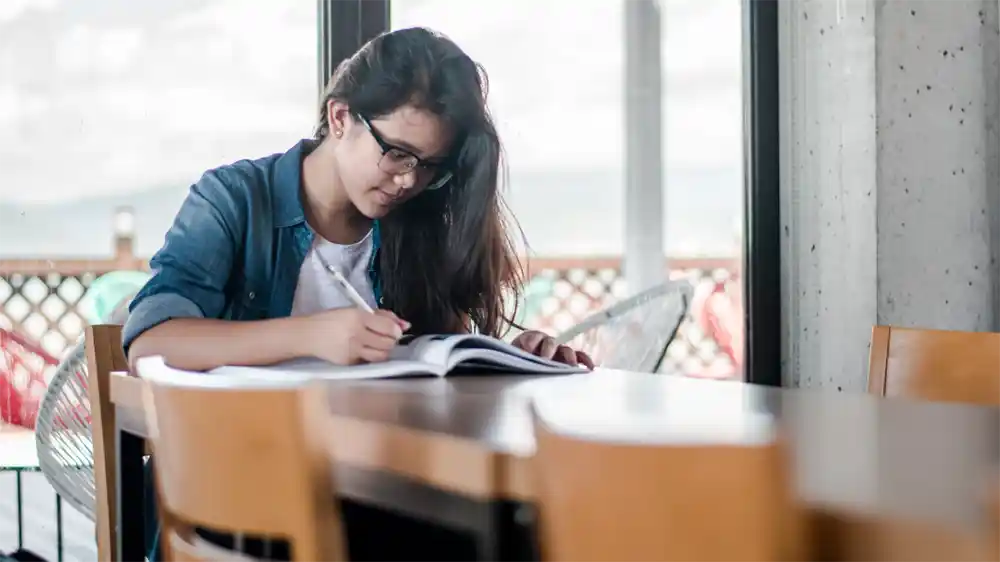 A young woman studying. Photo by Kyle Gregory Devaras on UnSplash.