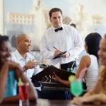 A waiter in a restaurant taking an lunch order