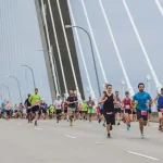 Runners crossing the Arthur Ravenel Jr Bridge for article "Cooper River Bridge Run maintains global appeal"