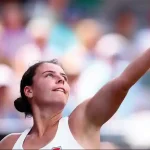 Emma Navarro looking up as she serves.