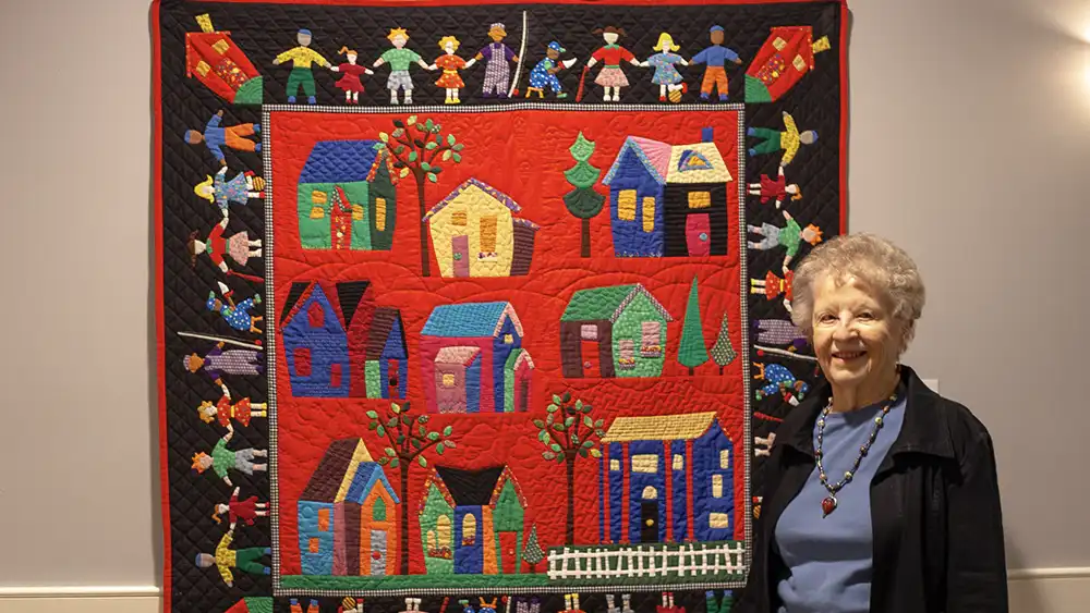 Jan Donovan stands next to one of her quilts. Photo by Rachel Basye, Cooper River Photography 