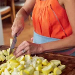 Carrie Morey, founder of Callie’s Hot Little Biscuit slicing yellow squash.