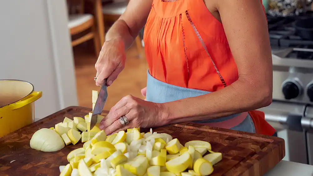 Carrie Morey, founder of Callie’s Hot Little Biscuit slicing yellow squash.