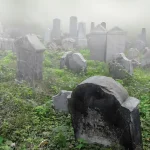 A foggy graveyard with several headstones