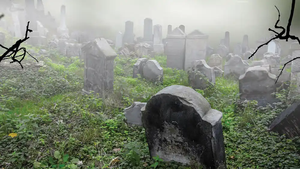 A foggy graveyard with several headstones