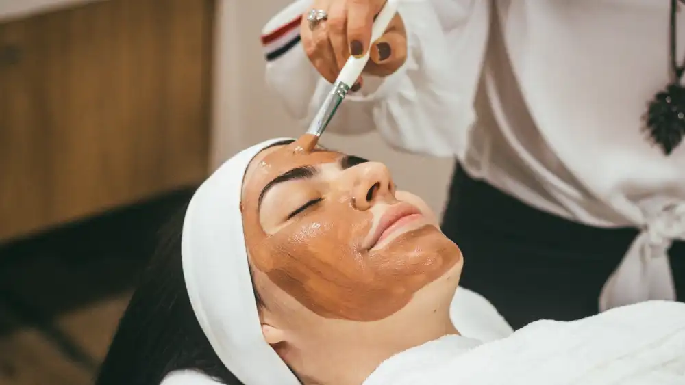 An aesthetician performs a facial treatment.