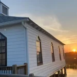 The Pawleys Island Chapel with the sun setting in the background in Pawleys Island, South Carolina.