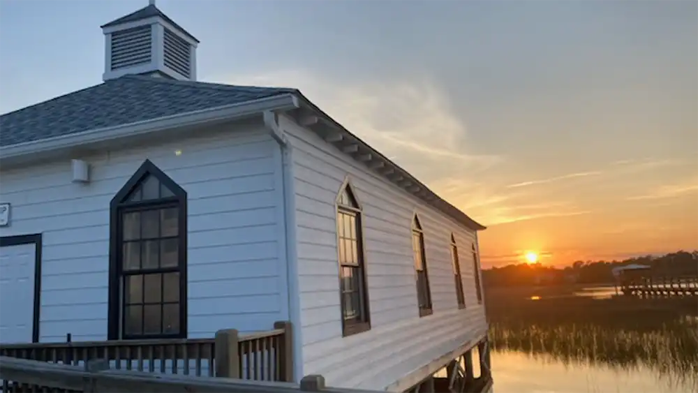 The Pawleys Island Chapel with the sun setting in the background in Pawleys Island, South Carolina.