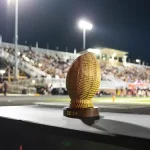 A Sweetgrass Bowl trophy sits on a table at a football game.