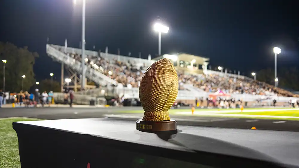 A Sweetgrass Bowl trophy sits on a table at a football game.