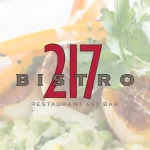 Bistro 217 logo with a background of scallops