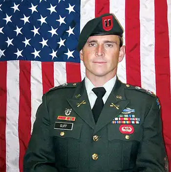 Photo pf CPT Richard “Richie” G. Cliff, Jr. in front of the American Flag. Photo credit https://arsof-history.org/fallen/2008_cliff_richard.html, an official Army website.