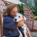 Anna Proleika with an adopted dog on her lap.