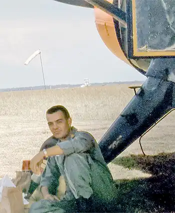 Capt. Hugh Reavis Nelson Jr sitting next to a helicopter. Photo courtesy of the US Army.