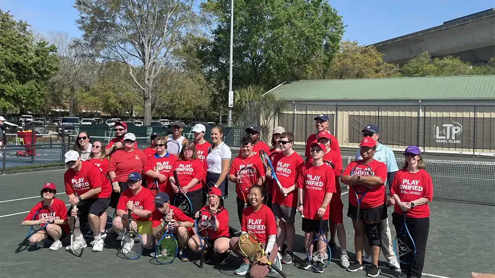 Special Olympics SC athletes and coaches pose with Shelby Rogers and Madison Keys after the tennis clinic.