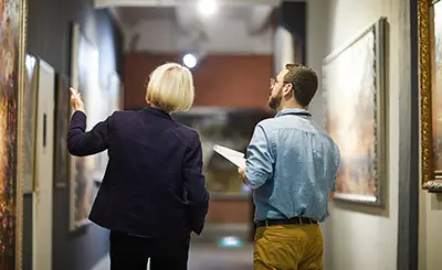 Art aficionados enjoying paintings at an art gallery
