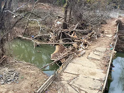 A washed out bridge in Asheville, NC after Hurricane Helene in 2024 showing debris on and near the bridge.