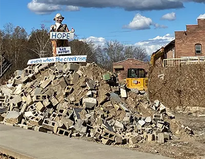 In the wake of Hurricane Helene in 2024, a sign on a pile of debris in Asheville, NC outside of VJ's Auto reads, &quot;HOPE... even when the creek rises&quot;